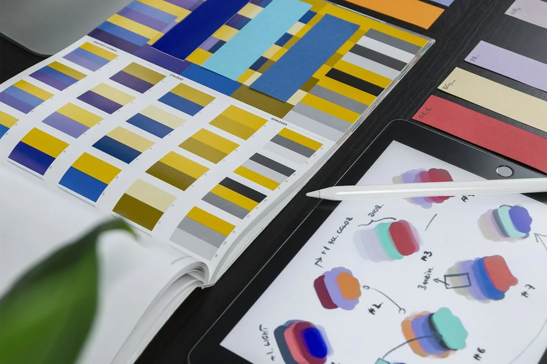 Color swatches and printed design layouts on a desk